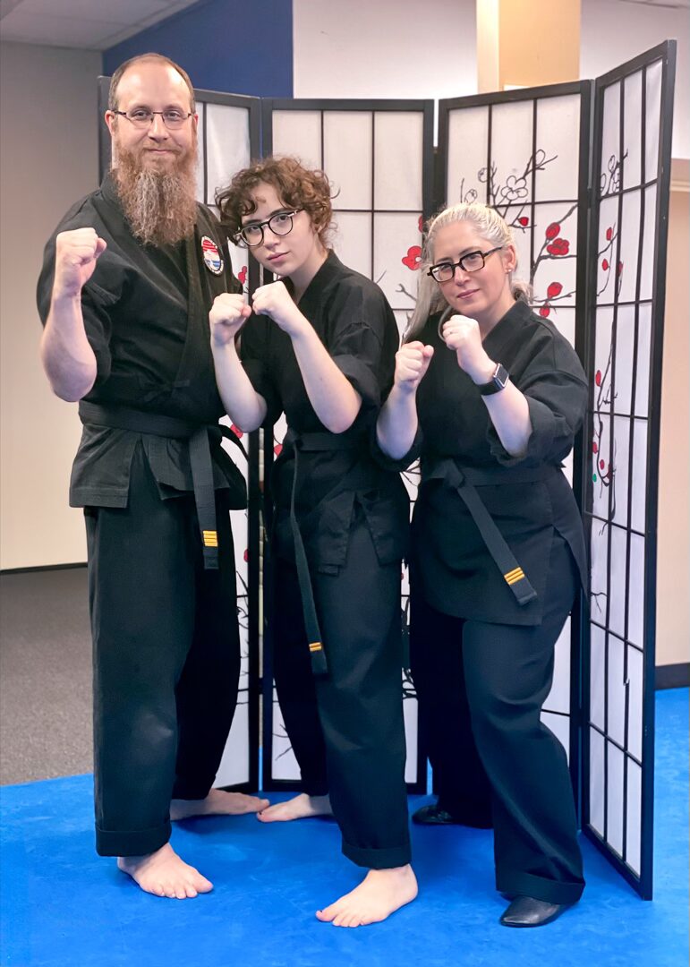 Jeremy Kriegel, Lilia Jacobs-Kriegel & Sharona Jacobs standing in their dogi's and black belts.